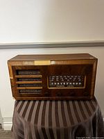 Front view of wooden Stromberg-Carlson radio on striped cloth