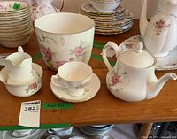 Front view of teapot, cup with saucer, creamer, sugar bowl showing pattern and shapes