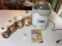 Bread maker, four ceramic canisters, manual displayed on table