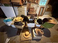 Overall view of table with multiple hats and hat boxes