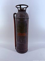Front view of copper and brass Imperial fire extinguisher with hose