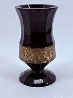 Full view of vase showing flared paneled body and gilded frieze