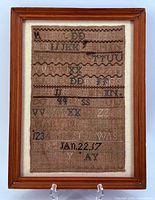 Full view of framed sampler showing entire stitched surface and wood frame