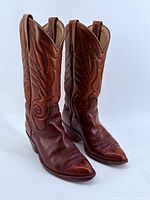 Front three-quarter view of both boots showing leather color, stitching, pointed toes, stacked heels