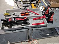 Full kit laid out in case showing jack, stands, chocks, handle, pliers