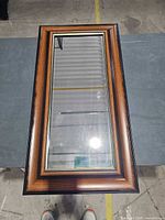 Front view of rectangular brown framed mirror