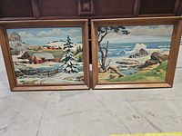 Both framed paintings side by side on floor showing overall look and size