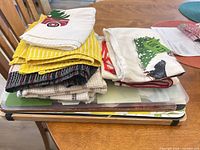 Stack of assorted towels on top of plastic chopping mats and bamboo board