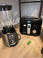 Oster blender with glass jar beside Starfrit fryer