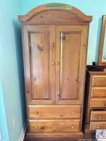 Front view of solid pine armoire showing doors and drawers