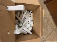 Open carton containing numerous Philips PL-C LED lamps