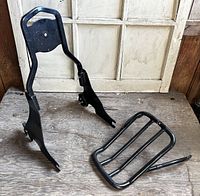 Sissy bar upright and luggage rack together on wooden surface