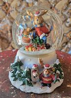 Front view of snow globe showing interior reindeer Santa and base decorations