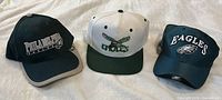 All three Philadelphia Eagles caps displayed side by side