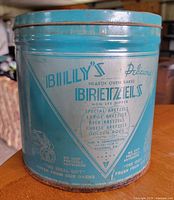 Side view showing branding and graphics on teal tin