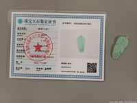 Certificate card beside jadeite pendant