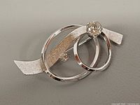 Front view of sterling silver brooch showing design and crystals