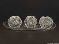 Front view showing three Snowball candle holders on tray