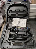 Open carry case showing rotary saw, cord, manuals and accessory packet
