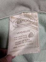 Tag showing Eaton Collection Européenne Versailles, pure virgin wool, double or queen, made in France, attached to light green fabric
