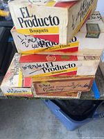 Stack of El Producto cigar boxes labeled 1/2" sockets, wrenches, picks etc.