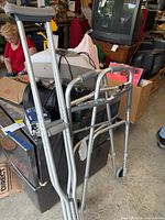 Walker and crutches standing together, showing aluminum frames and rubber tips