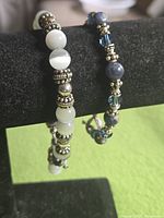 Front view of both stone bead bracelets on display stand