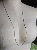 Full view of necklace draped in single long length on mannequin
