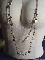 Full view of necklace on dress form showing two strands and mixed bead/disc drops