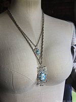 Necklace on mannequin showing chain length and both owl pendants