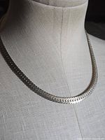Front view of silver-tone flat chain collar necklace on mannequin