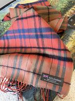 Close-up of plaid cashmere scarf showing label and fringe