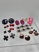 Overall view of all 12 earring pairs on acrylic stand