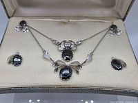 Full set displayed inside box showing both necklaces and four earrings