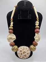 Full view of necklace on display bust showing overall design and components