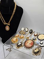 Group shot of all cameo jewelry pieces on acrylic stand and bust