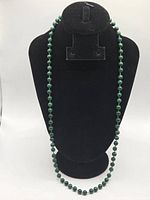 Full view of malachite bead necklace on display bust