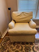Front view of cream upholstered armchair