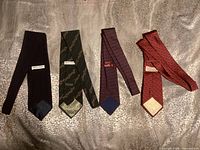 Four silk designer ties laid out side by side