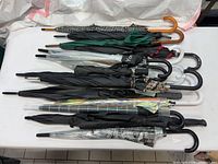 Side view of stacked umbrellas showing varied crook handles and canopies