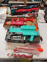 Overall view of three blasters with packaging on table