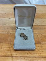 Charm and box open on wood surface