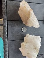 Two quartz specimens next to coin for scale