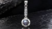 studio image of silver pendant with dark pearl