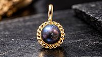 Front view of silver pendant with dark pearl