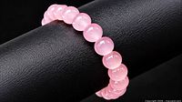 Full bracelet on display rod showing uniform pink beads