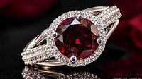 Close-up angled view of ring showing garnet, CZ halo, split shank