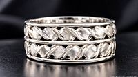 angled view of silver ring showing braided design