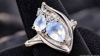 Front angled view showing two pear moonstones, clear accent stones, marquise bezel