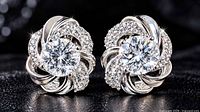 Front view of both silver stud earrings showcasing white quartz centres and CZ accents